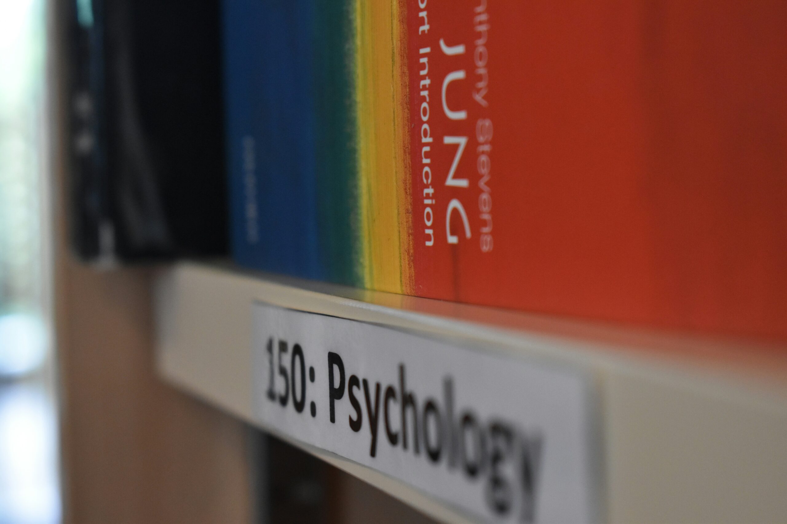 Estantería con libros de psicología y otros temas.