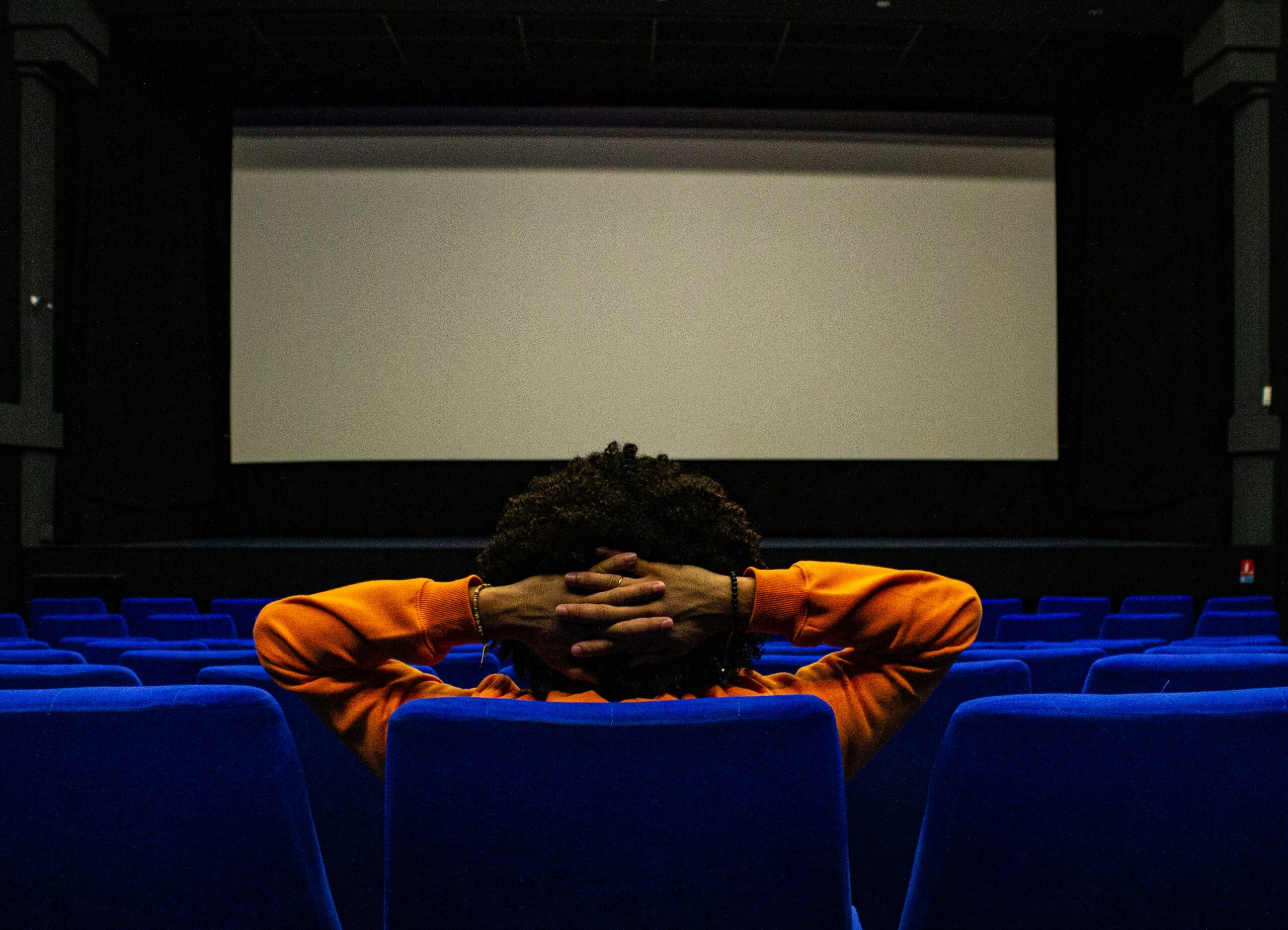 Hombre solo en cine reflexionando sobre relaciones tóxicas en peliculas.