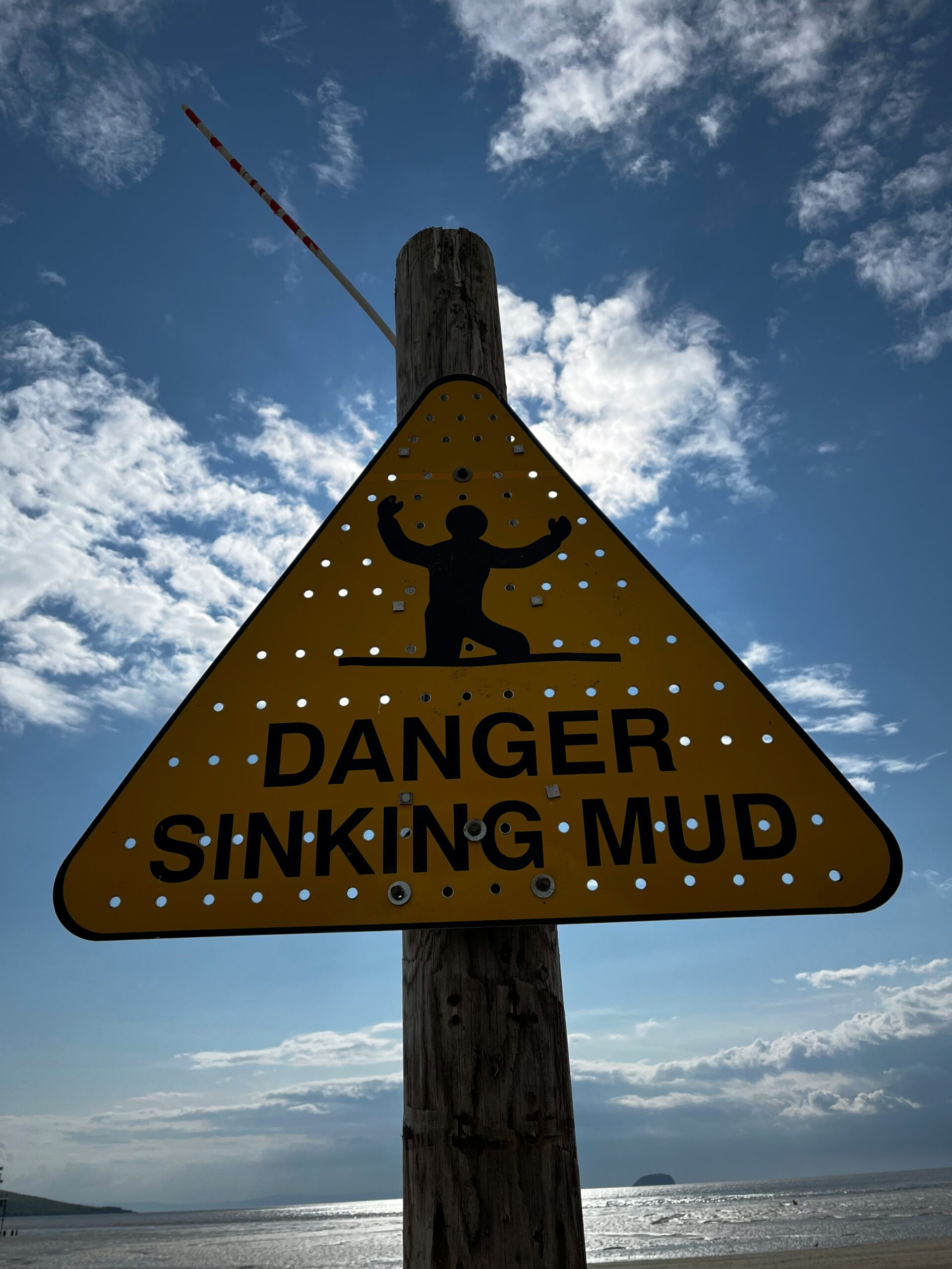 Señal de advertencia en la playa ilustrando el efecto Dunning