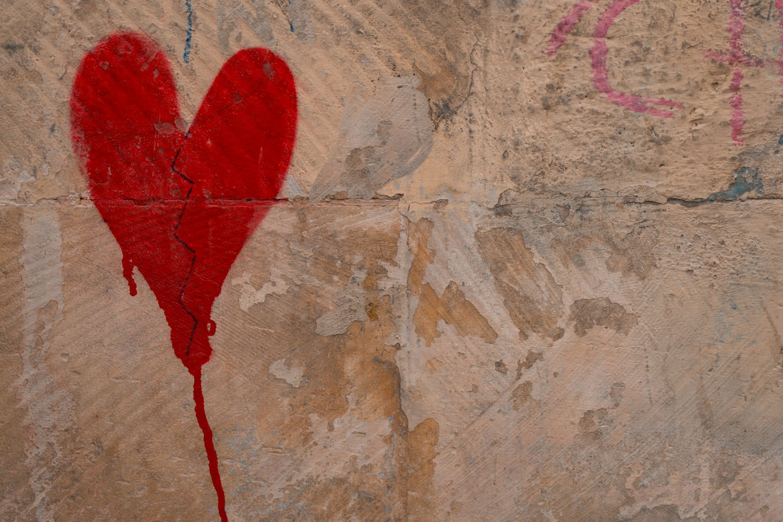 Trampas Psicológicas en el Amor: ¿Por qué Caemos en los Mismos Errores? 1 Corazón rojo pintado en pared y trampas psicológicas del amor.